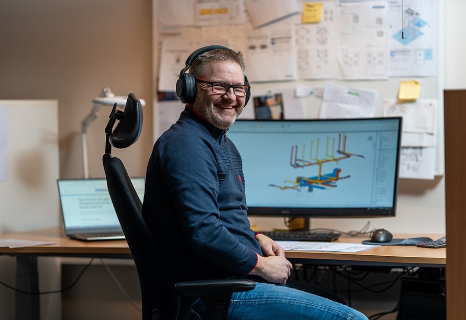 Ansatt som jobber med teknisk prosjekteringstegning ved skrivebordet