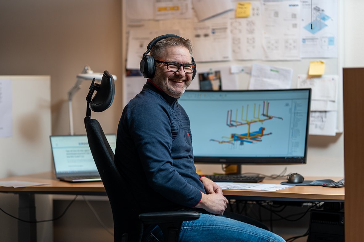 Ansatt i prosjekteringsavdelingen ved skrivebord med teknisk tegning på skjerm