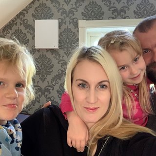 Single room ventilator wall-mounted in a home office, shown in a residential setting with family present.