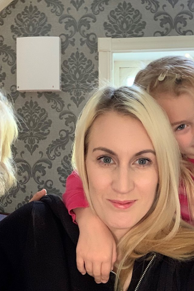 Single room ventilator wall-mounted in a home office, shown in a residential setting with family present.