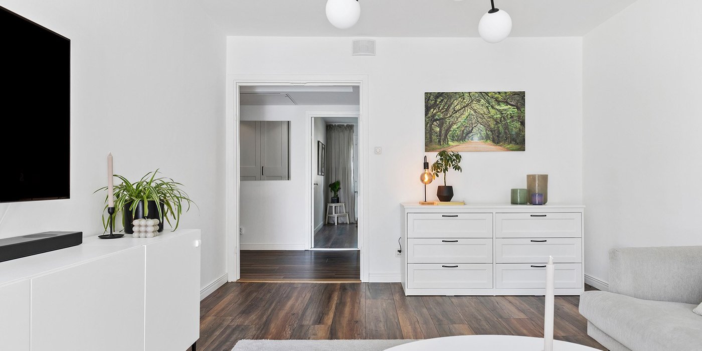 Stue i renovert leilighet med tilluftsdon montert på vegg.