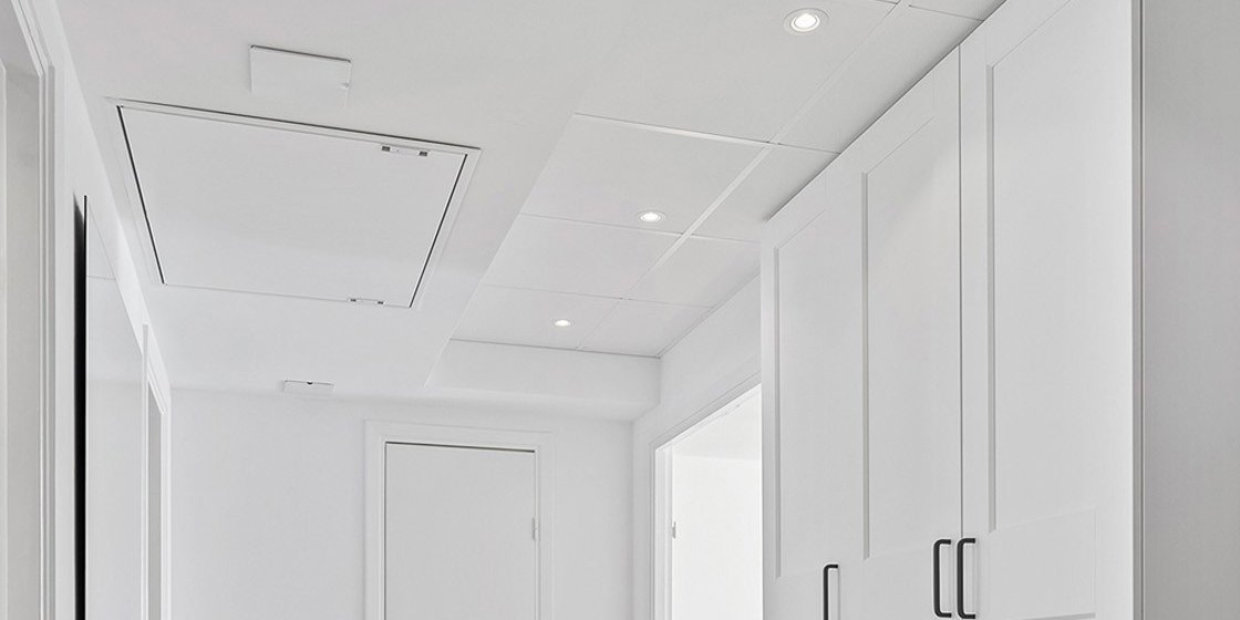 Gang i renovert leilighet med balansert ventilasjonsaggregat diskret montert i himlingen.