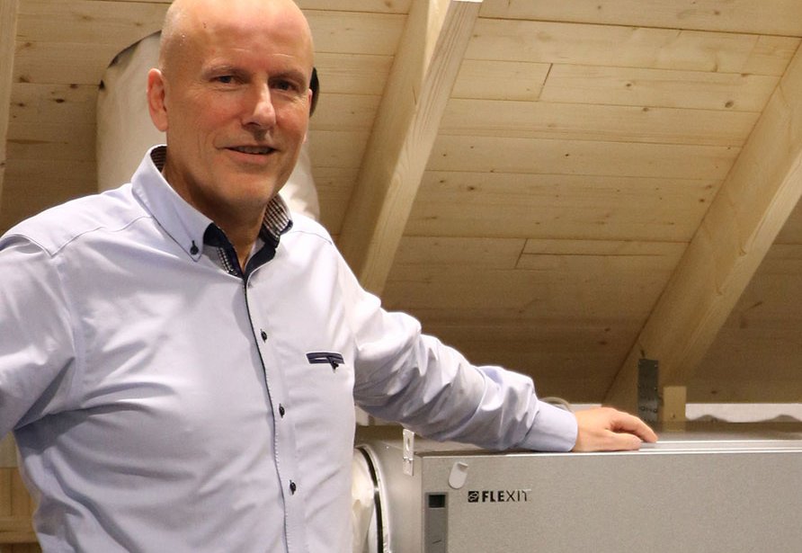 Tre personer står ved siden av en Flexit-utstilling med Stage Wheel lakkert i gull.