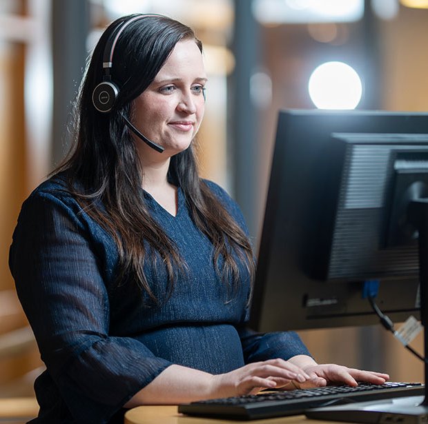 Flexit employee working at a computer with headset in an office environment
