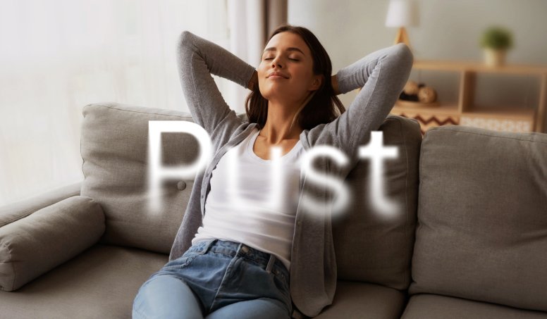 Kvinne slapper av i en sofa i en lys stue.
