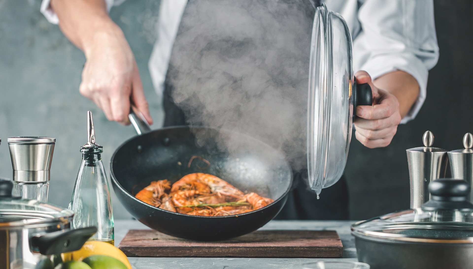 Damp stiger fra matlaging i panne på kjøkken.